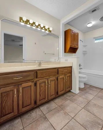 a spacious bathroom with a granite countertop sink and a mirror