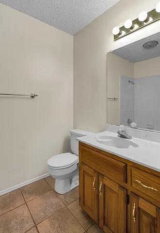 a bathroom with a granite countertop sink a toilet and a mirror