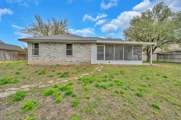 a large tree in front of a house with a yard