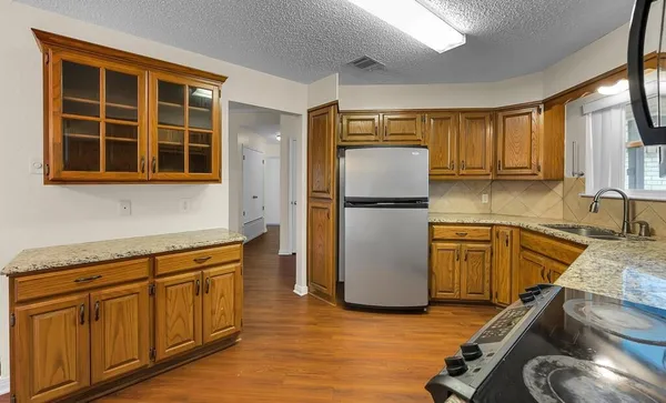 a kitchen with sink refrigerator and cabinets