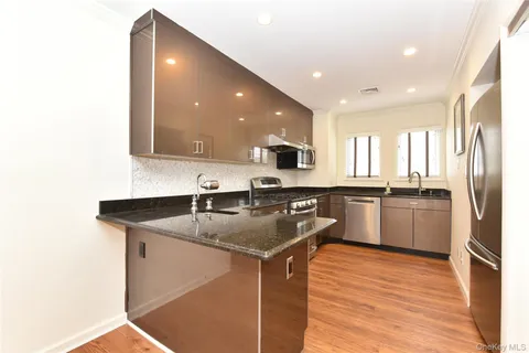 a kitchen with stainless steel appliances granite countertop a sink stove and refrigerator