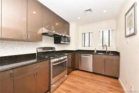 a kitchen with stainless steel appliances granite countertop a stove a sink and a granite counter tops