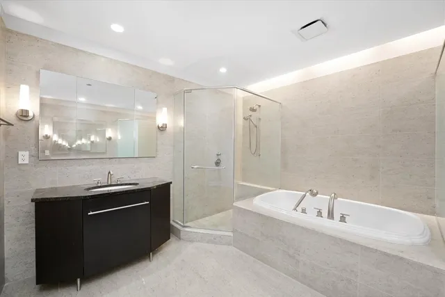 a bathroom with a granite countertop sink mirror and bathtub