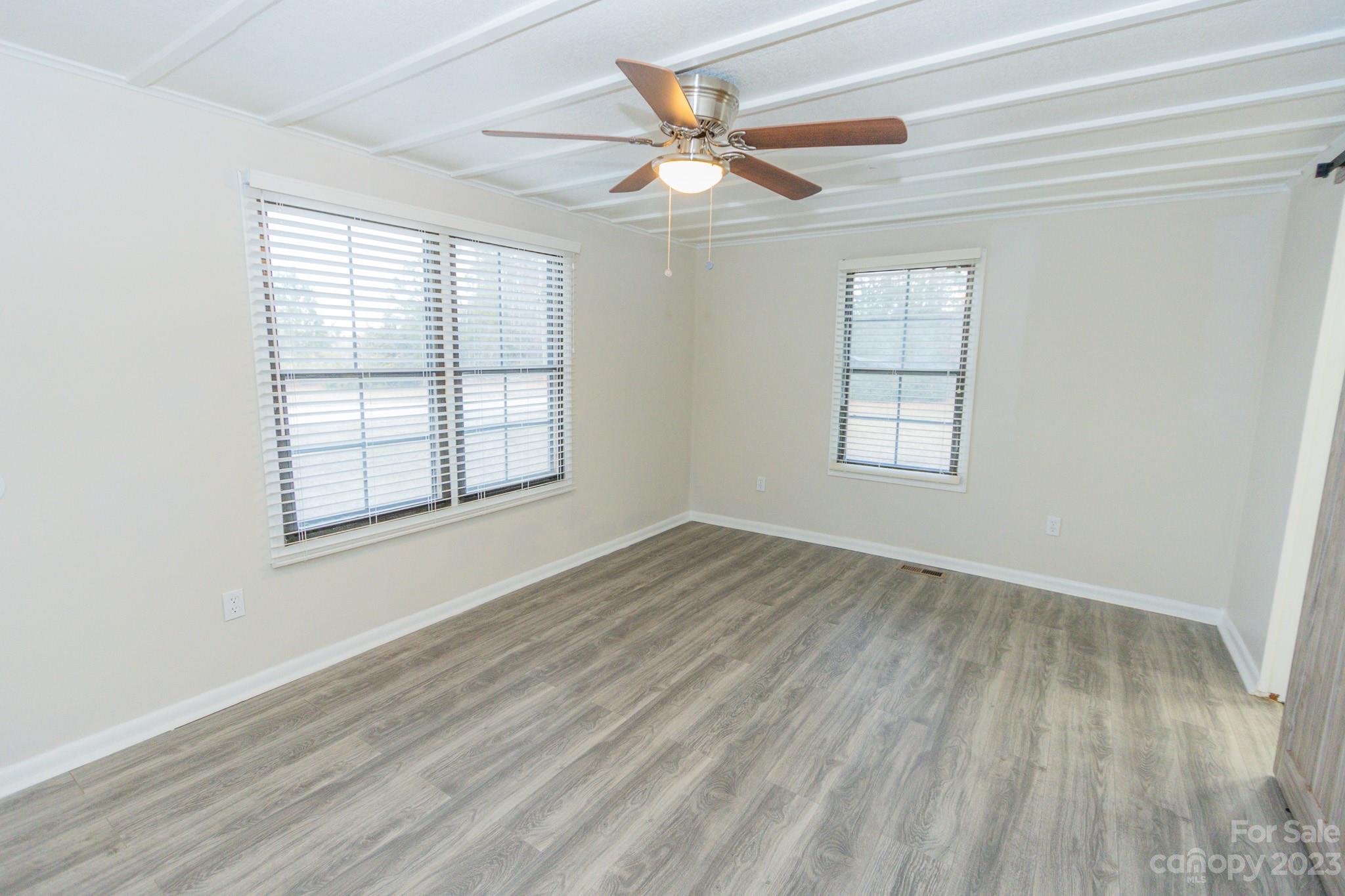 4634 Pleasant Road Heath Springs, SC 29058 - Photo 12 of 43 an empty room with wooden floor windows and fan