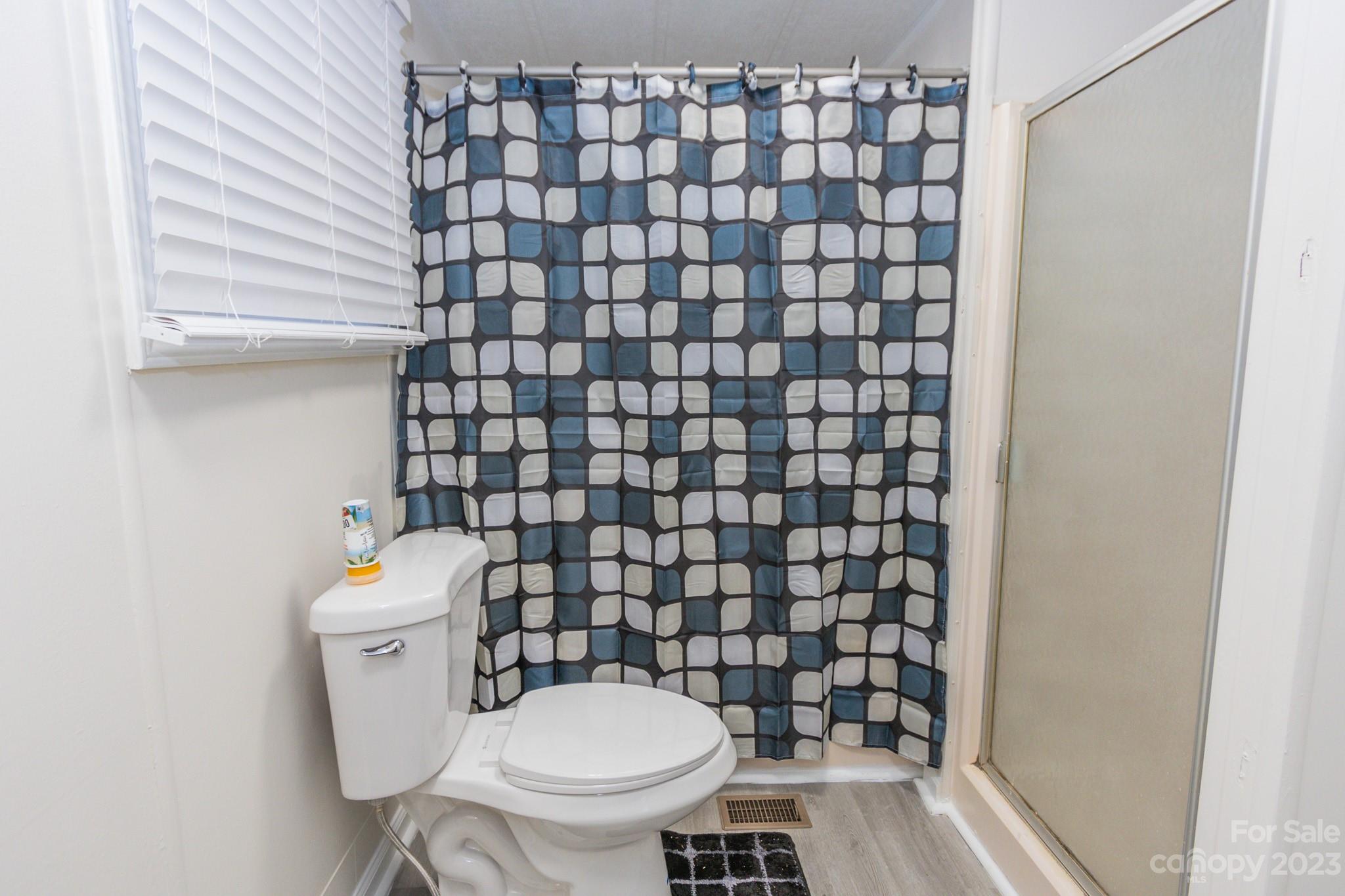 4634 Pleasant Road Heath Springs, SC 29058 - Photo 16 of 43 a white toilet sitting next to a shower curtain
