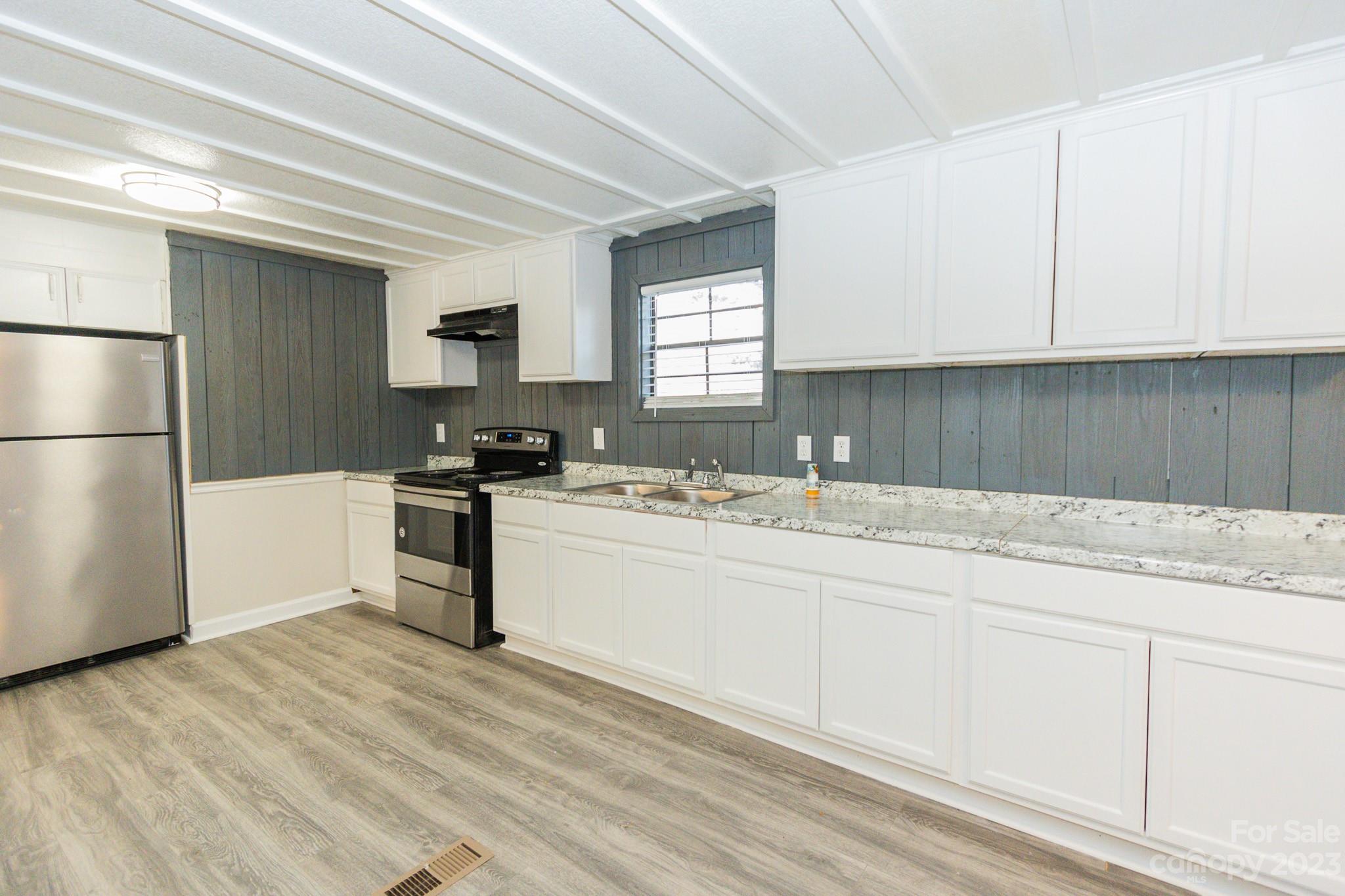 4634 Pleasant Road Heath Springs, SC 29058 - Photo 22 of 43 a kitchen with granite countertop white cabinets and refrigerator
