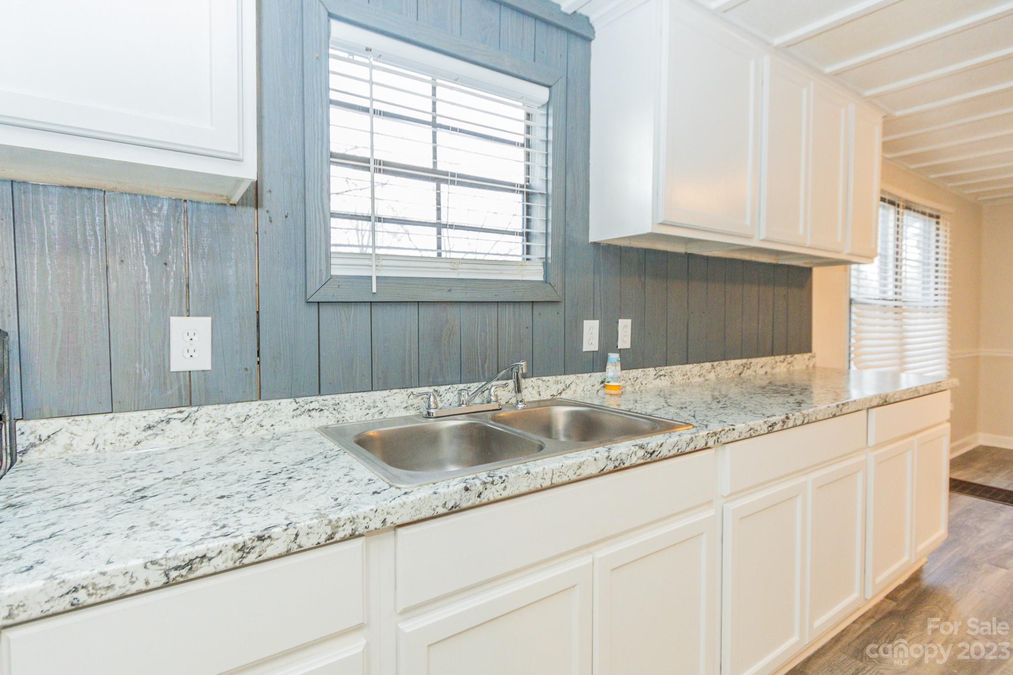 4634 Pleasant Road Heath Springs, SC 29058 - Photo 26 of 43 a kitchen with granite countertop a sink and white cabinets
