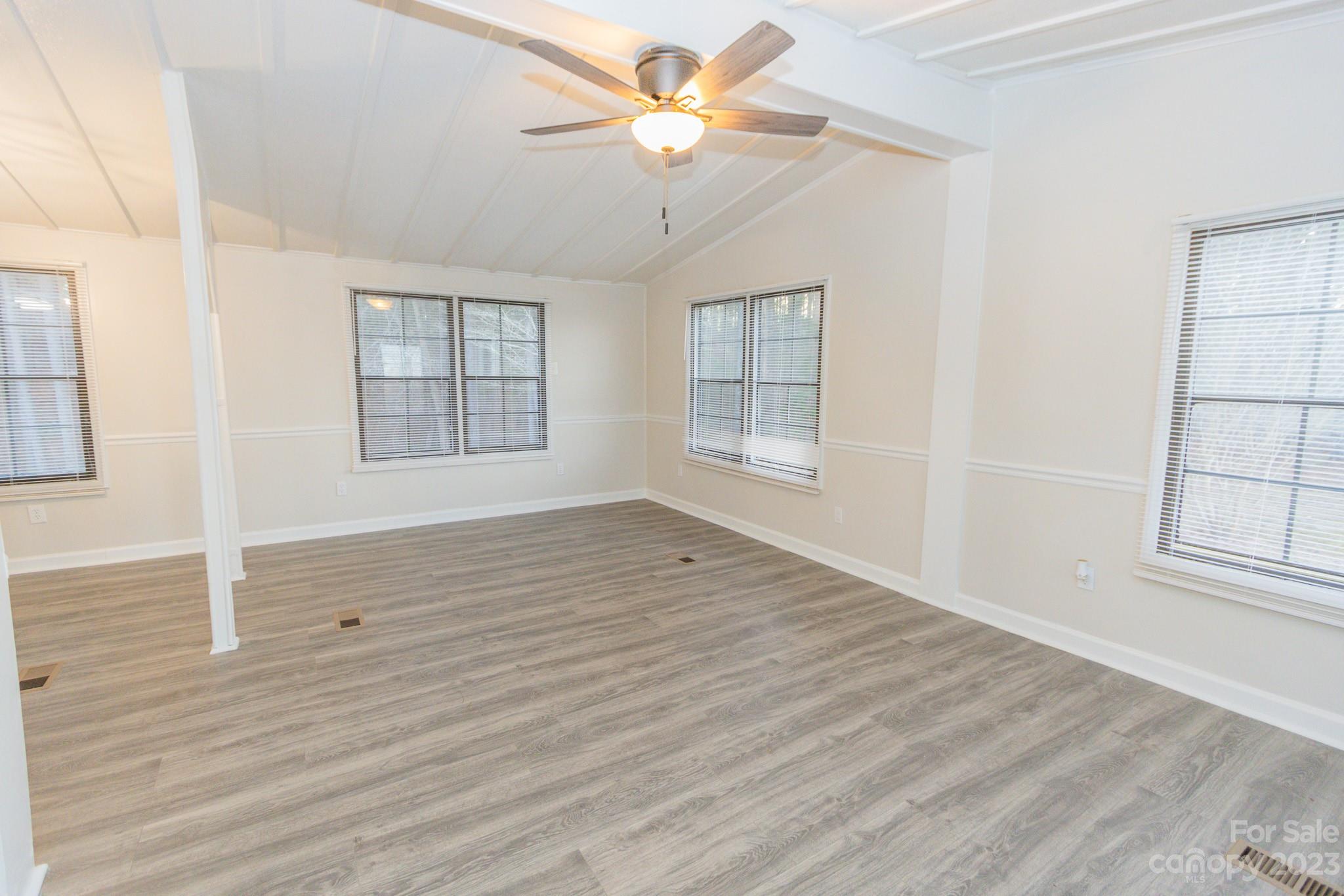 4634 Pleasant Road Heath Springs, SC 29058 - Photo 30 of 43 an empty room with wooden floor chandelier fan and windows