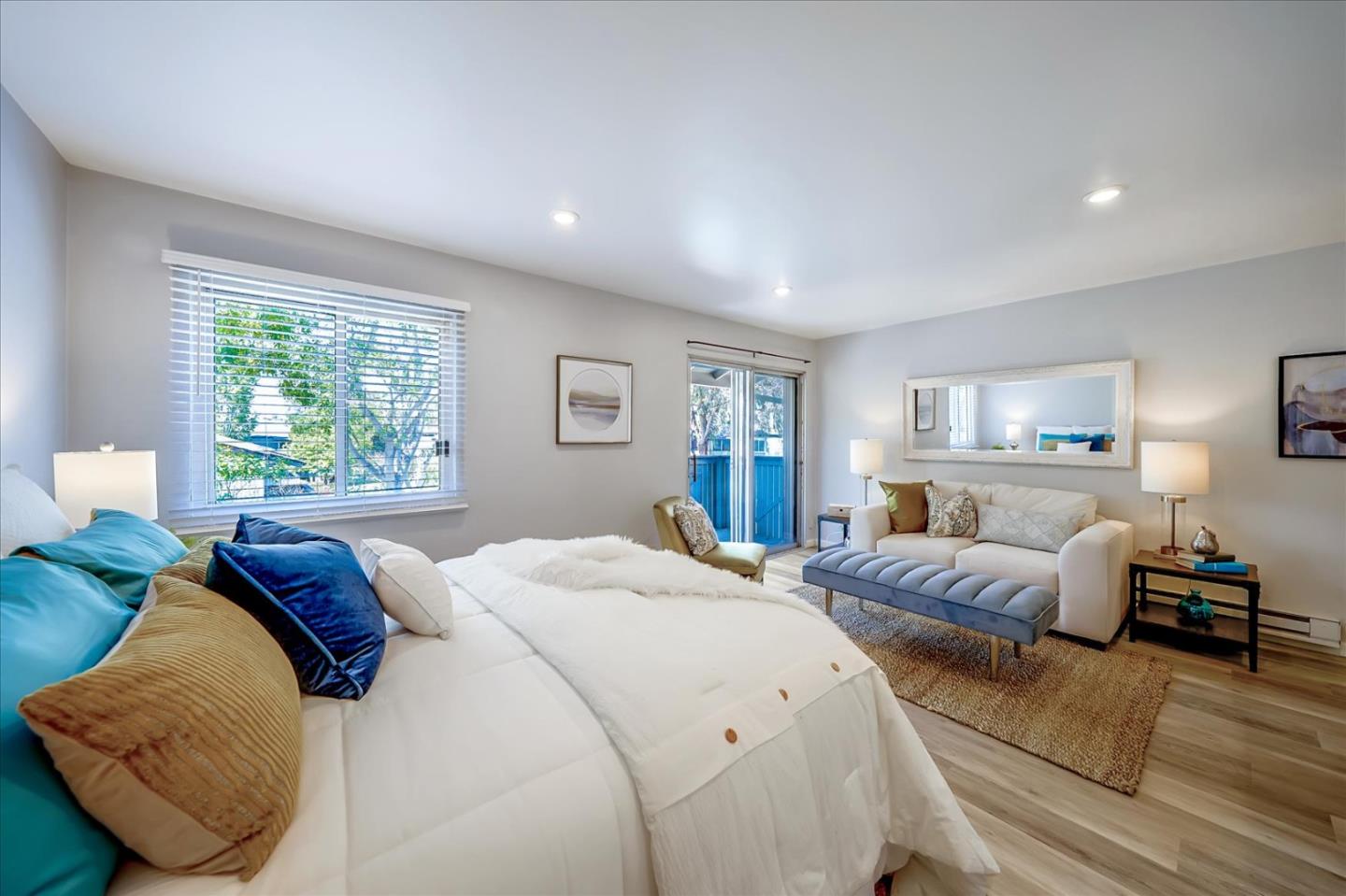 a bedroom with a large bed and wooden floor