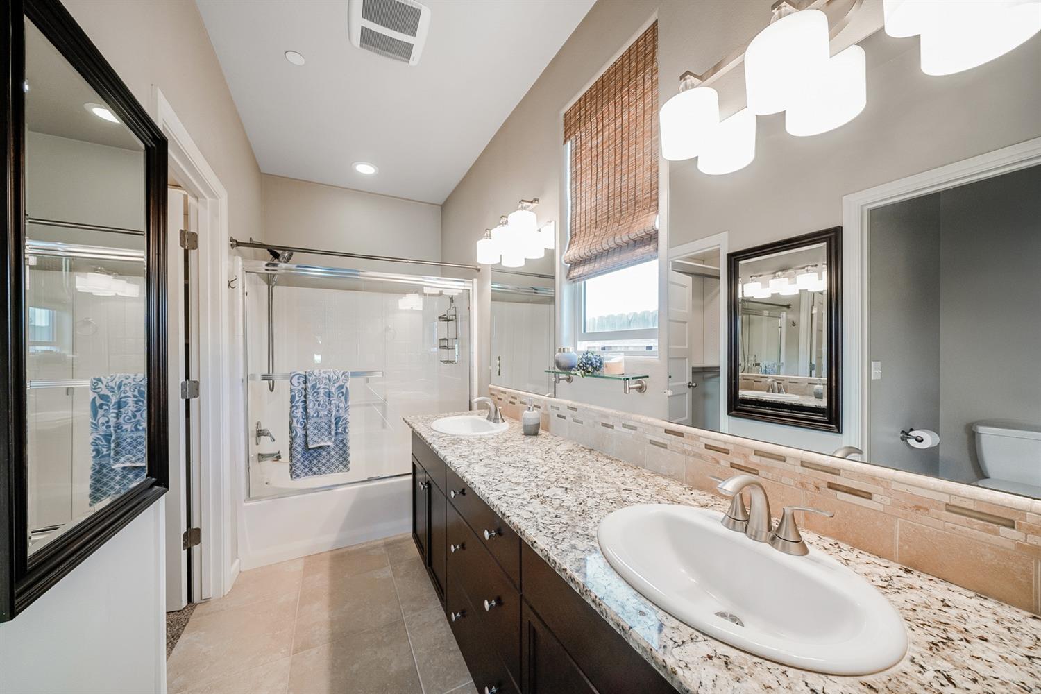 3563 Journey Way Clovis, CA 93619 - Photo 4 of 20 a bathroom with a granite countertop sink mirror and a shower