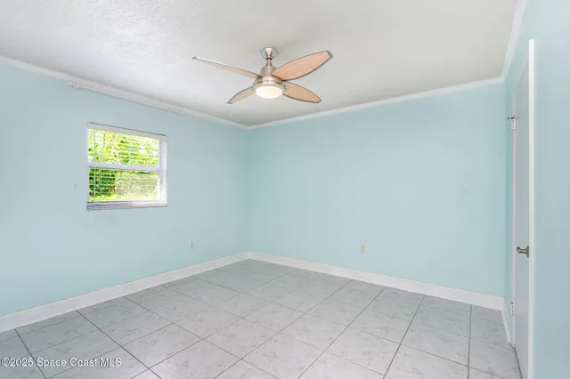 an empty room with windows and fan
