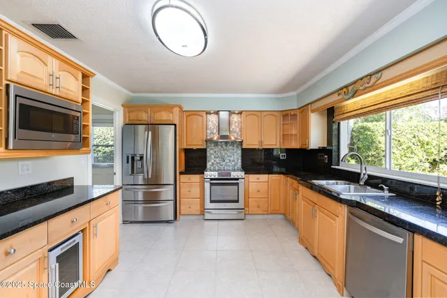 a kitchen with stainless steel appliances granite countertop a stove a sink and a refrigerator