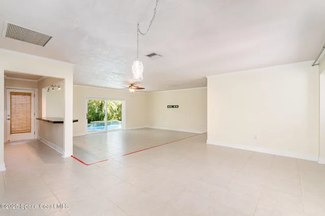 an empty room with kitchen and windows