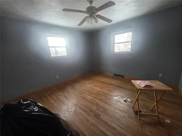 a view of a room with wooden floor air conditioner and windows