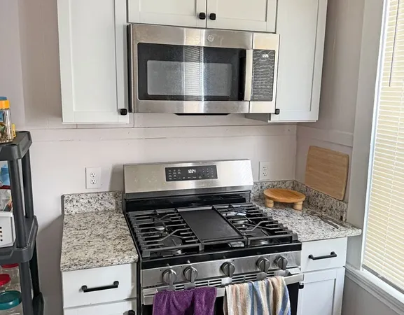 a kitchen with stainless steel appliances granite countertop a stove and a microwave