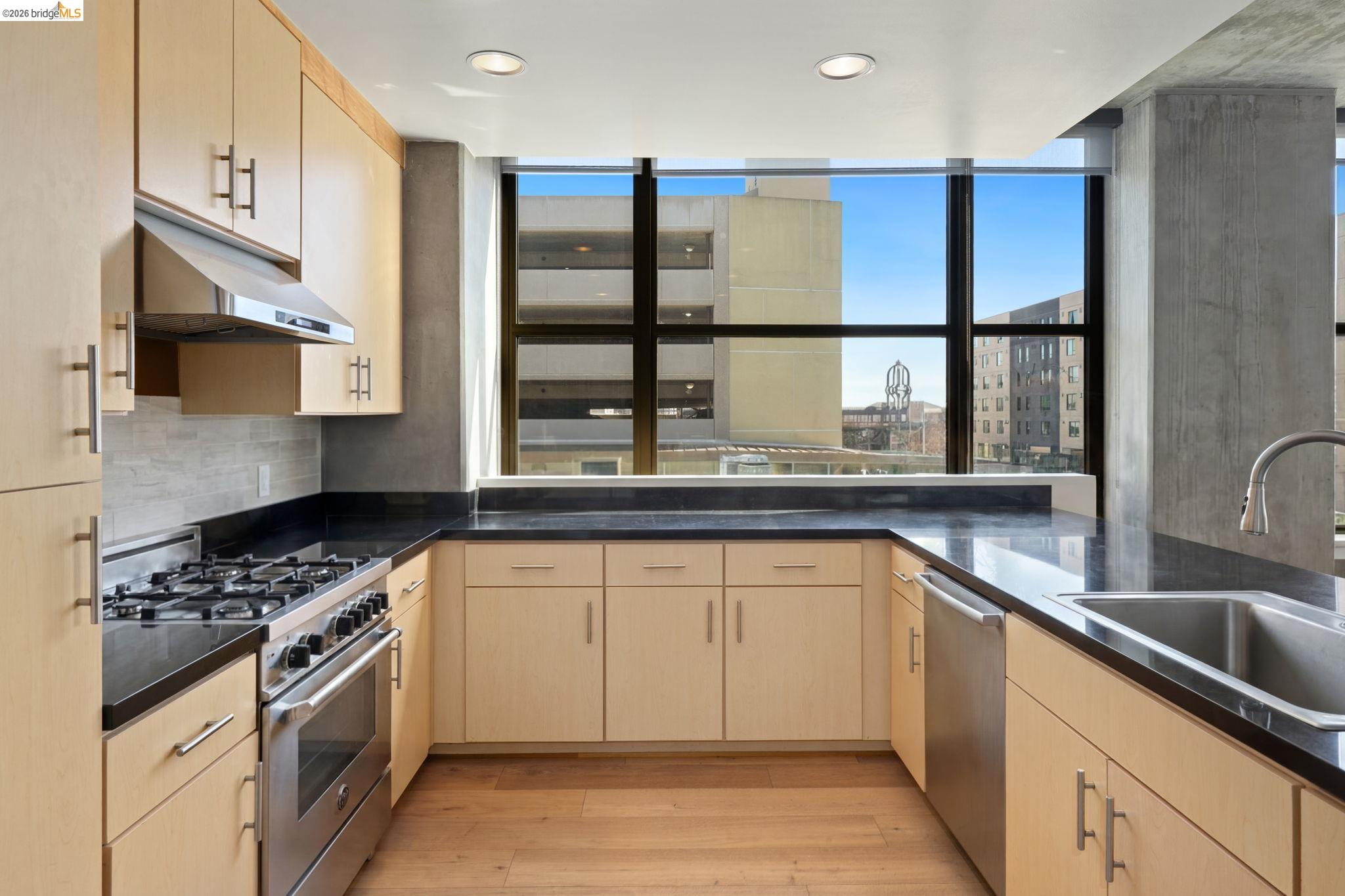 311 2nd Street, Unit 511 Oakland, CA 94607 - Photo 20 of 44 Kitchen with stainless steel appliances, light wood finish cabinetry, light wood-style floors, decorative backsplash, and recessed lighting