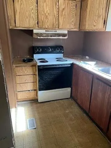 a stove top oven sitting inside of a kitchen