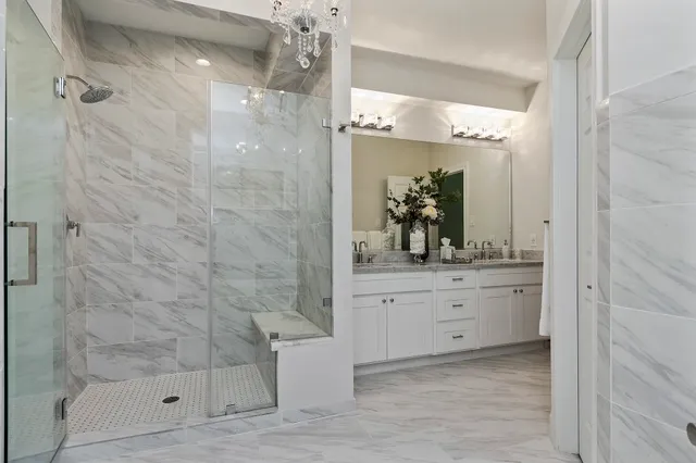 a bathroom with a granite countertop shower a mirror and a sink