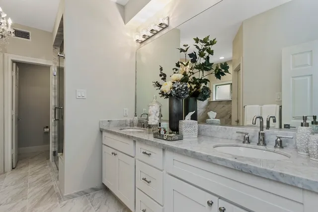 a bathroom with a granite countertop sink a large mirror and a shower