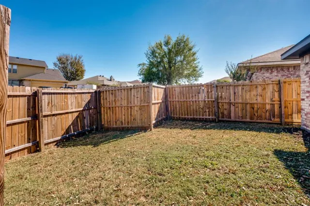 a view of a backyard with wooden fence