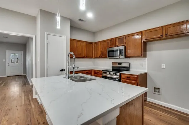 a kitchen with a sink a microwave a stove and refrigerator