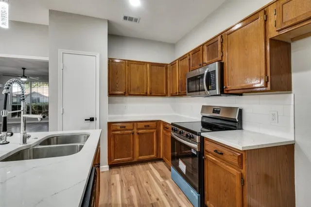 a kitchen with stainless steel appliances granite countertop a sink stove and microwave
