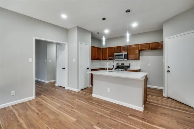 a view of kitchen with granite countertop cabinets and refrigerator