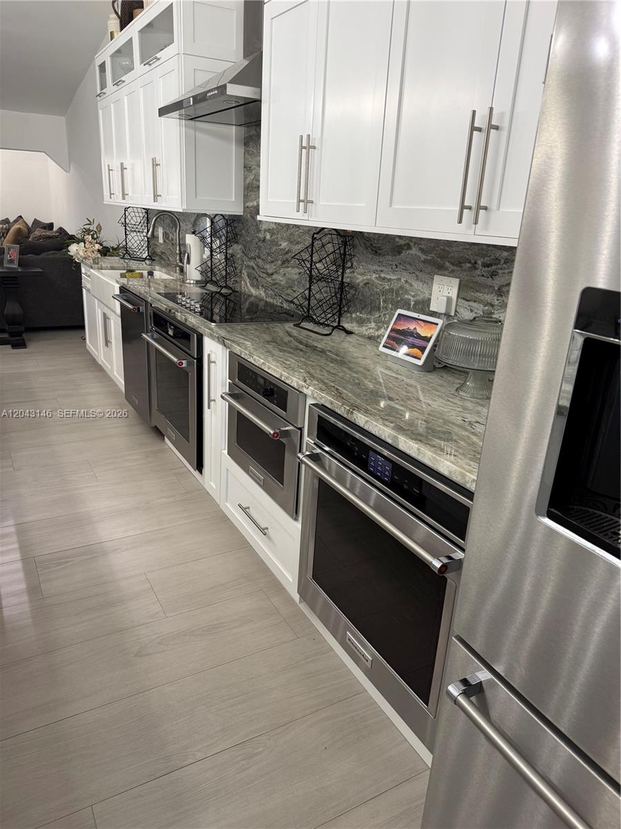 4947 Southwest 143rd Avenue Miami, FL 33175 - Photo 8 of 19 The kitchen's counter depth refrigerator, two ovens, microwave/oven, dishwasher, ceramic stove top, hood, and Kohler farm sink. All appliances are top of the line, KitchenAid, appliances.