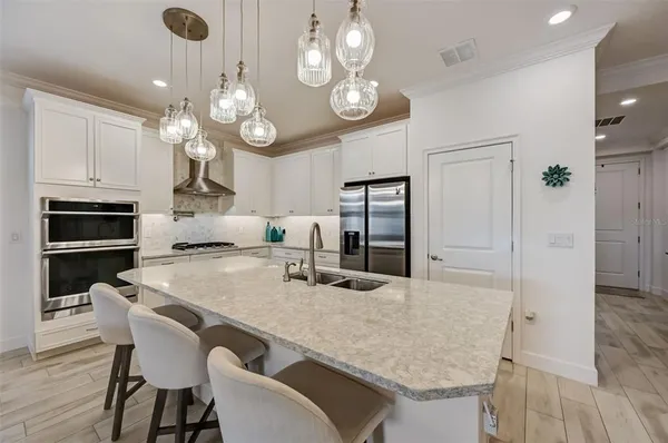 a kitchen with a table chairs sink and cabinets