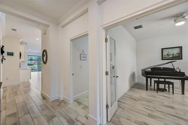 a view of a hallway with wooden floor and a piano
