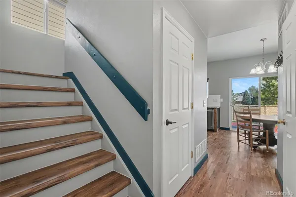 a view of a hallway with wooden floor and staircase