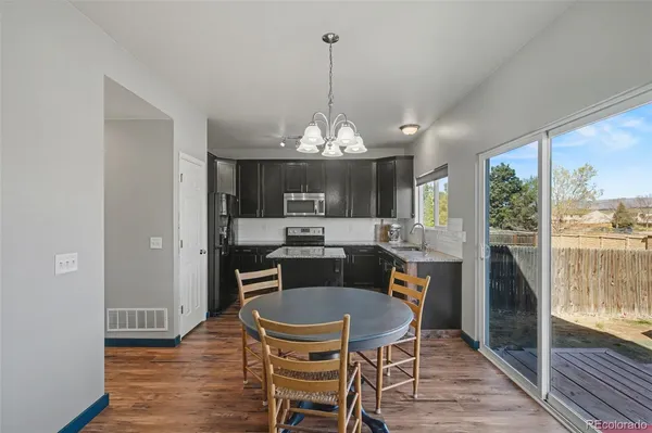 a dining room with furniture a chandelier and wooden floor
