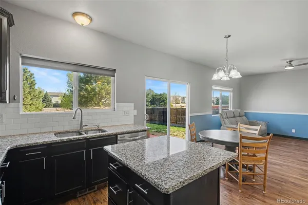 a kitchen with a table chairs and wooden floor
