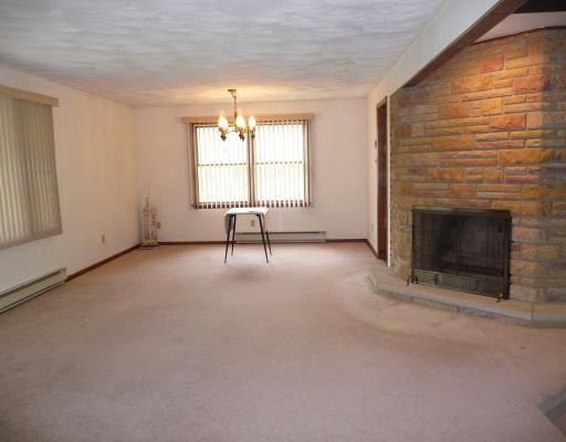 10440 Five Points Road Home, PA 15747 - Photo 3 of 12 Living Room. Open area of LR/DR with stone fireplace and large windows.