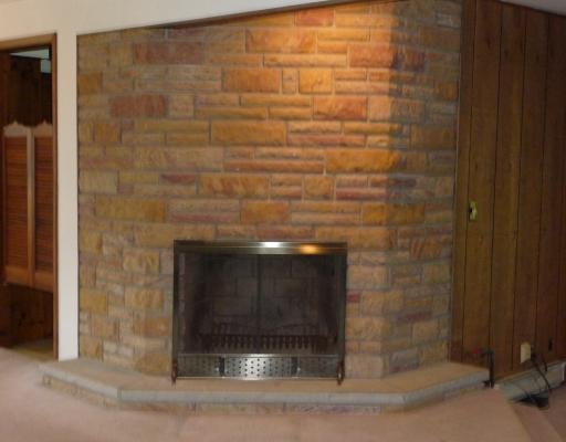 10440 Five Points Road Home, PA 15747 - Photo 5 of 12 Living Room. Closeup of beautiful stone woodburning or gas fireplace in living room. Swinging doors to left open to kitchen.