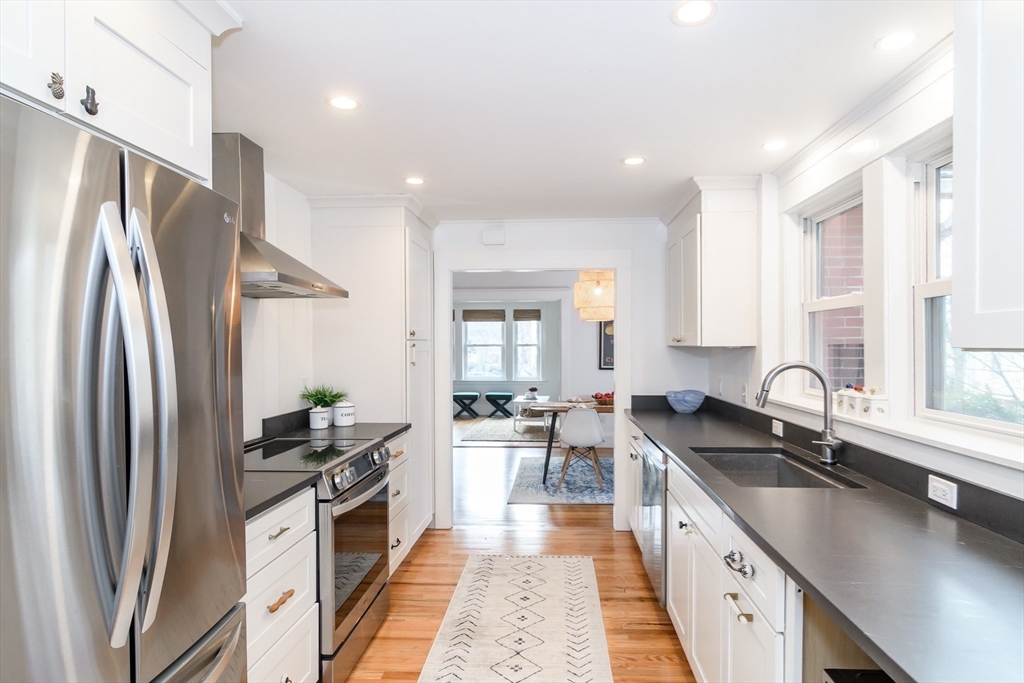 32 Harvard Street Natick, MA 01760 - Photo 11 of 24 a kitchen with stainless steel appliances a sink stove and refrigerator