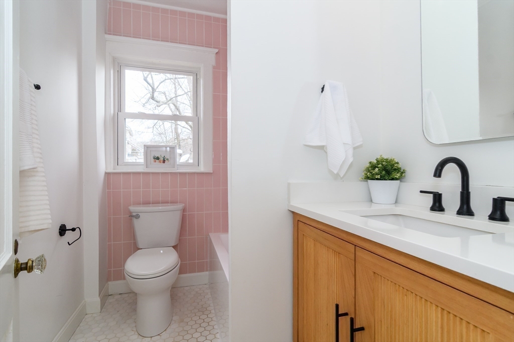 32 Harvard Street Natick, MA 01760 - Photo 14 of 24 a bathroom with a granite countertop sink a toilet and a window
