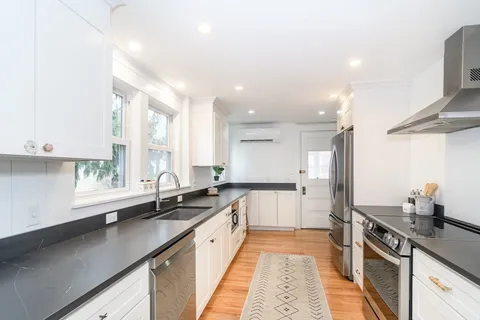 a large kitchen with stainless steel appliances a sink dishwasher a stove and a refrigerator