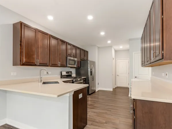 a kitchen with stainless steel appliances granite countertop wooden cabinets a sink dishwasher a stove and a refrigerator