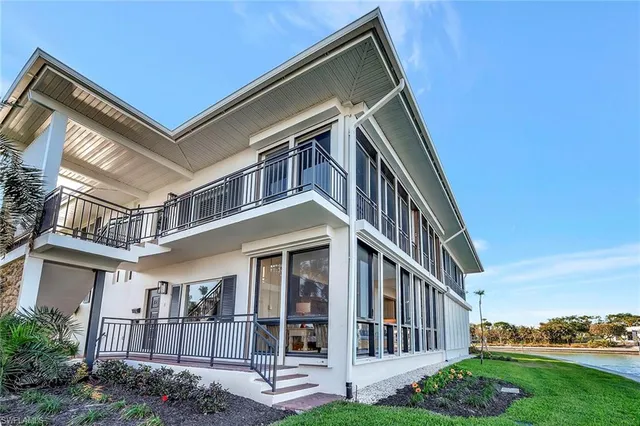 a view of a lake with a big yard and large trees