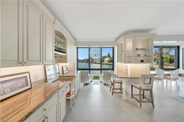 a open kitchen with stainless steel appliances granite countertop a stove a sink and a dining table with granite countertops