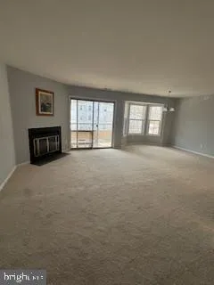 a view of an empty room with window and fireplace