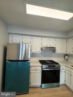 a kitchen with stainless steel appliances granite countertop a refrigerator and a stove