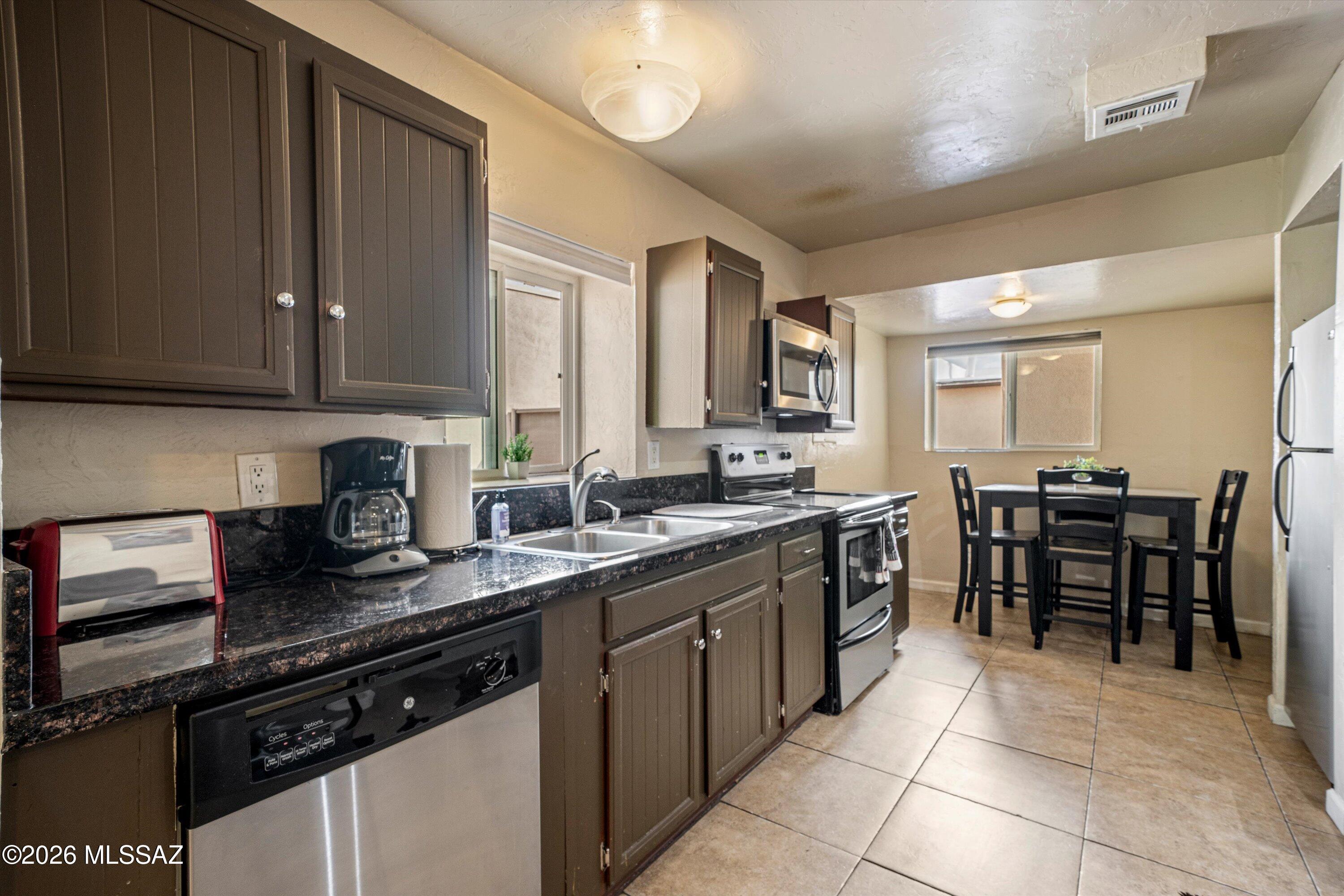2619 East Prince Road Tucson, AZ 85716 - Photo 42 of 50 a kitchen with a sink a counter top space appliances and cabinets