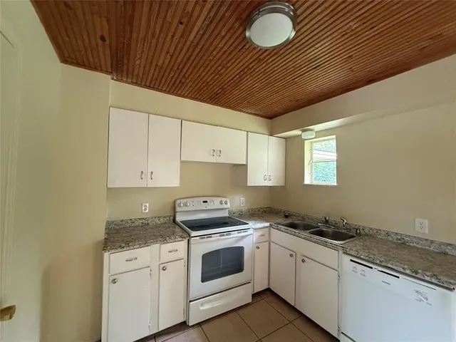 a kitchen with granite countertop a stove sink and cabinets