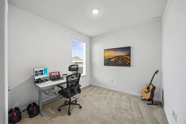 a view of a workspace with furniture and a window