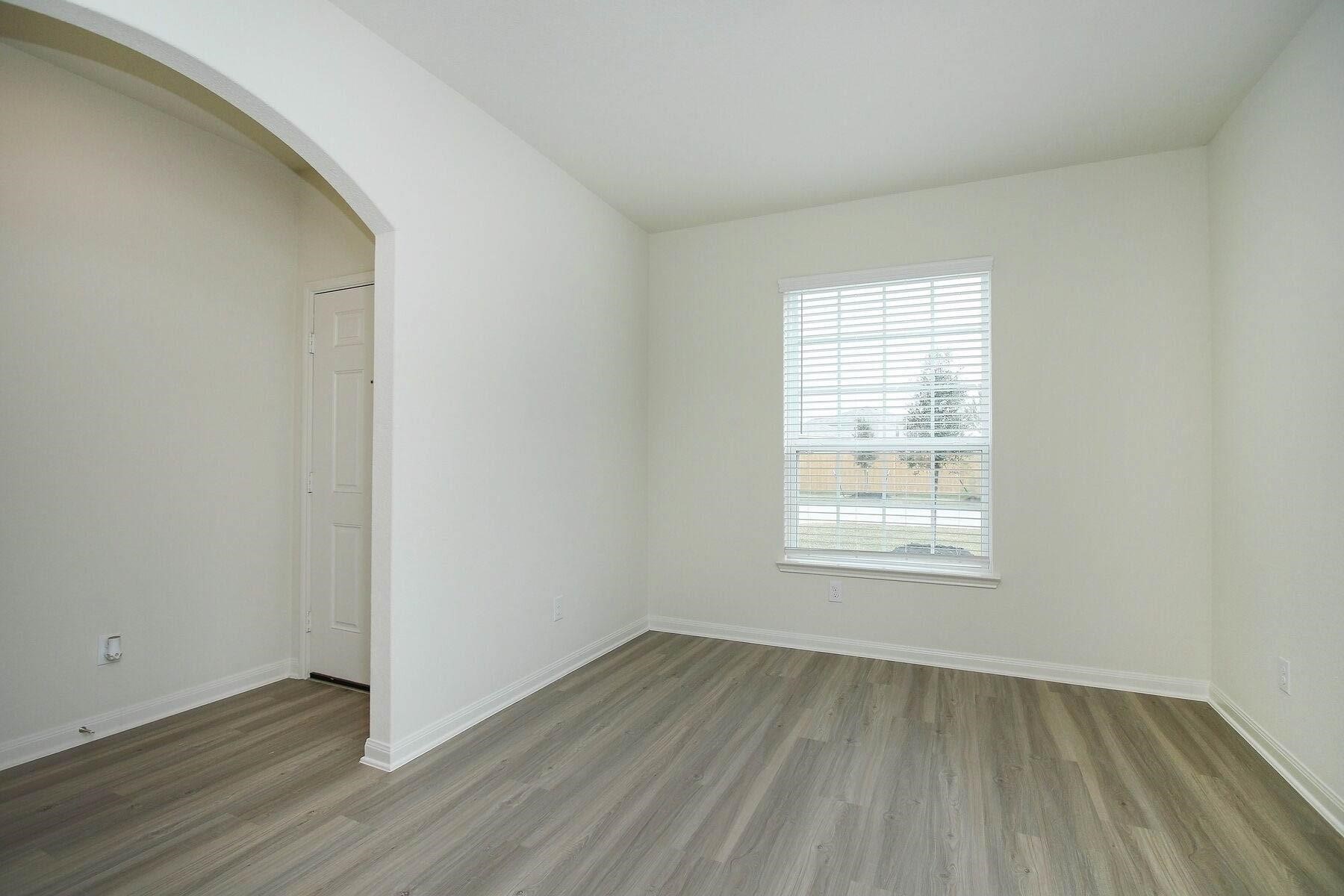 22422 Kennons Way Hockley, TX 77447 - Photo 2 of 11 an empty room with wooden floor and windows