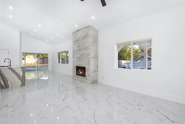 a view of an empty room with a fireplace and a window