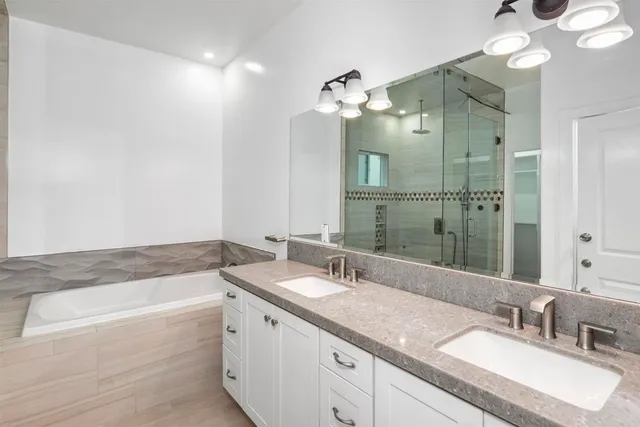 a bathroom with a granite countertop double vanity sink and mirror