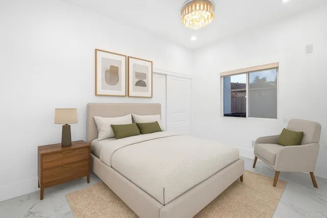 a bedroom with a bed and a chandelier